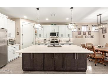 Modern kitchen with a large island, stainless steel appliances, pendant lights, and white cabinetry at 2306 N Floyd Dr, Mesa, AZ 85215