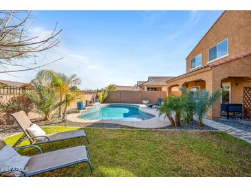 Relaxing backyard oasis with a pool, lawn area, and patio at 2404 E Gillcrest Rd, Gilbert, AZ 85298