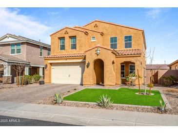 Two-story house with tan exterior, three-car garage, and landscaped front yard at 2404 E Gillcrest Rd, Gilbert, AZ 85298