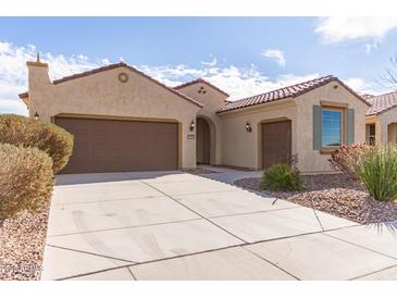 Single-story home with a two-car garage and desert landscaping at 5575 W Cinder Brook Way, Florence, AZ 85132