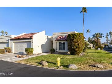 Exterior view of a charming condo with a two-car garage and desert landscaping at 663 S Saguaro Way, Mesa, AZ 85208