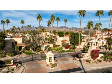 Beautiful community view with lush landscaping, palm trees, and mountain views in a gated community at 10050 E Mountainview Lake Dr # 39, Scottsdale, AZ 85258