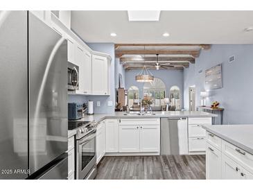 Bright kitchen with white cabinets, stainless steel appliances, and open to the living space at 10050 E Mountainview Lake Dr # 39, Scottsdale, AZ 85258