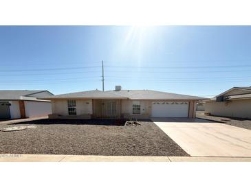 Ranch style home with a single garage and gravel driveway at 10437 W Caron Dr, Sun City, AZ 85351