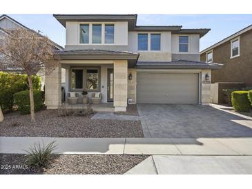 Inviting two-story home boasts neutral tones, low-maintenance landscaping, and a welcoming covered porch at 14369 W Wethersfield Rd, Surprise, AZ 85379