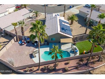 Aerial view of a private backyard featuring a pool, patio and artificial turf at 16934 N 158Th Ave, Surprise, AZ 85374