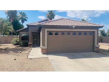 Charming single-story home featuring a well-kept front yard, and a two car garage at 16934 N 158Th Ave, Surprise, AZ 85374