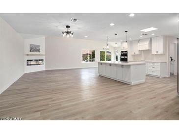 Modern white kitchen with large island and stainless steel appliances at 17831 N 130Th Ave, Sun City West, AZ 85375