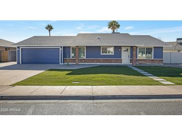 Newly renovated home with a blue exterior, brick accents, and a well-manicured lawn at 1845 E Hampton Ave, Mesa, AZ 85204