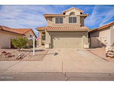 Two-story house with tan exterior, two-car garage, and a pool in the backyard at 19410 N 77Th Dr, Glendale, AZ 85308