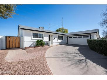 Charming single-story home featuring a well-manicured lawn and a spacious driveway leading to an attached two-car garage at 2113 N 66Th St, Scottsdale, AZ 85257