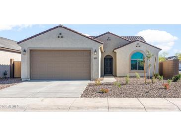 Charming single-story home featuring a two-car garage, tiled roof, and desert landscaping for low maintenance appeal at 6383 W Georgetown Way, Florence, AZ 85132