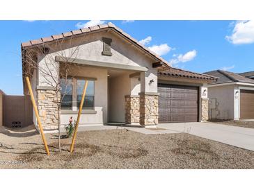 Charming single-story home with desert landscaping, stone accents, and a two-car garage at 7548 W Park St, Laveen, AZ 85339