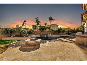 Peaceful backyard at sunset with a fire pit and pool at 10410 N 74Th Pl, Scottsdale, AZ 85258