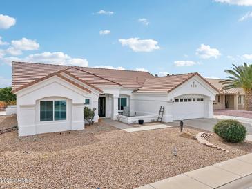 Charming single-story home with tile roof, white exterior and two car garage at 14701 W Sentinel Dr, Sun City West, AZ 85375