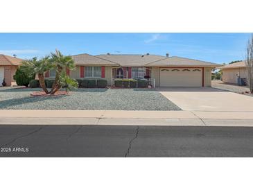Ranch-style home with a two-car garage and landscaped front yard at 15809 N Bowling Green Dr, Sun City, AZ 85351