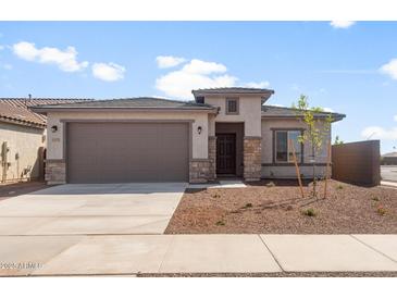 Beautiful single-story home with a well-manicured front yard and a two car attached garage at 17875 W Getty Dr, Goodyear, AZ 85338