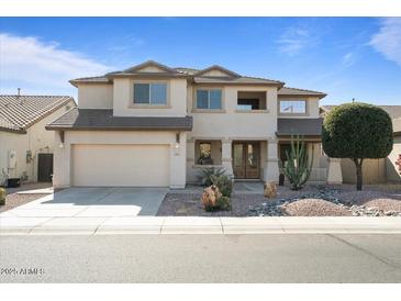 Two-story home featuring stucco exterior, desert landscaping, attached two car garage, and a covered front entryway at 18017 W Desert Ln, Surprise, AZ 85388
