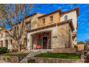Charming two-story home with a welcoming front porch, landscaping, and terra cotta roof tiles at 21134 W Sunrise Ln, Buckeye, AZ 85396
