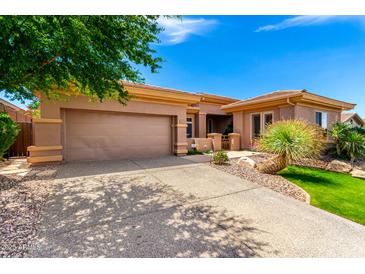 Beautiful single-story home featuring a well-manicured front yard and an attached two-car garage at 42017 N Crooked Stick Rd, Anthem, AZ 85086