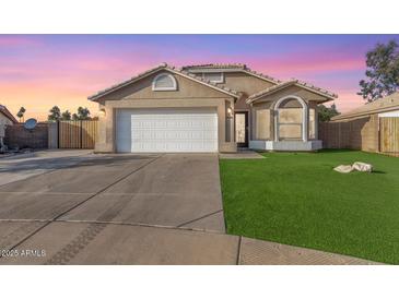 House exterior featuring a two-car garage and well-manicured lawn at 4446 W Townley Ave, Glendale, AZ 85302
