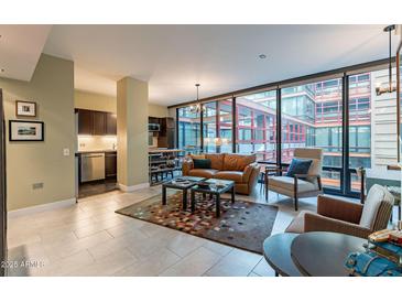 Open living area with leather sofa, large windows, and city views at 4808 N 24Th St # 305, Phoenix, AZ 85016