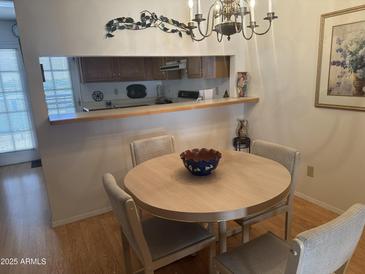 Bright dining area with a round table and four chairs, offering a view of the kitchen at 5518 E Lindstrom Ln # 2004, Mesa, AZ 85215