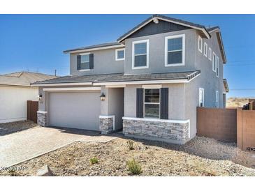 Charming two-story home featuring stone accents, neutral paint, an attached two-car garage and a low maintenance front yard at 9036 S 196Th Dr, Goodyear, AZ 85338