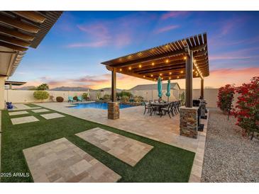 Outdoor patio with pergola, dining area, and built-in BBQ at 18125 W Acacia Dr, Goodyear, AZ 85338