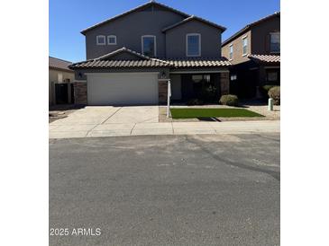 Two-story house with gray exterior, white garage door, and landscaped yard at 28756 N Desert Hills Dr, San Tan Valley, AZ 85143