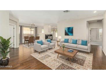 Inviting living room featuring hardwood floors, modern furniture, and an open layout to the dining area at 41216 N Shadow Creek Ct, Anthem, AZ 85086