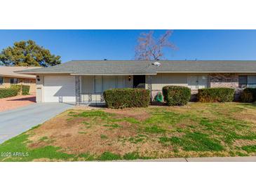 Ranch style home with attached garage and well-manicured lawn at 10450 W Campana Dr, Sun City, AZ 85351