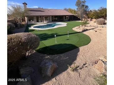 Desert backyard featuring a pool, putting green, patio, and low-maintenance landscaping at 22973 N 91St Way, Scottsdale, AZ 85255