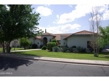Charming home with a red tile roof, circular driveway and lush, green landscaping at 4119 E Glencove St, Mesa, AZ 85205