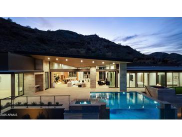 Luxury home with a stunning pool and mountain views at night at 6516 E Meadowlark Ln, Paradise Valley, AZ 85253