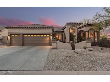 Beautiful home featuring desert landscaping, a three-car garage, and an arched entryway at 7735 E Russell Cir, Mesa, AZ 85207