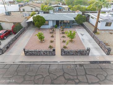 Aerial view of charming home featuring rock-lined yard, mature landscaping, and expansive driveway at 9410 N 4Th Ave, Phoenix, AZ 85021