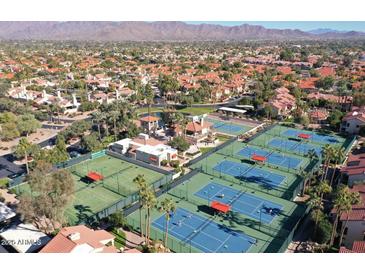Aerial view of community with tennis courts, pool, and mountain backdrop at 9707 E Mountain View Rd # 2430, Scottsdale, AZ 85258