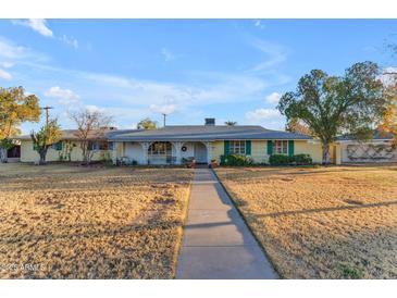 Charming single-story home with a welcoming front porch, mature trees, and expansive front yard at 2011 W Cambridge Ave, Phoenix, AZ 85009