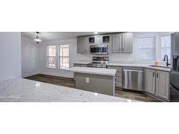 Charming kitchen features stainless steel appliances, a center island, and white stone countertops at 3104 E Broadway Rd # 16, Mesa, AZ 85204