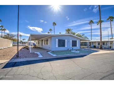 Charming single-story home featuring covered parking and a well-maintained yard with palm trees, creating a welcoming curb appeal at 3104 E Broadway Rd # 4, Mesa, AZ 85204
