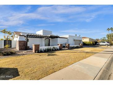 Modern, two-story home with an open pergola, brick accents, and a drought-tolerant front yard at 9136 N 81St St, Scottsdale, AZ 85258