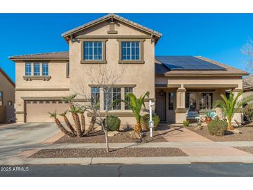 Beautiful two-story home featuring a desert landscape, solar panels, and a charming front porch at 11866 N 143Rd Ave, Surprise, AZ 85379
