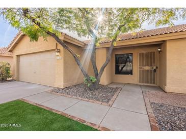 Charming single-story home with mature tree, low maintenance landscaping and two car garage at 1225 E San Angelo Ave, Gilbert, AZ 85234