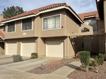 Multi-level townhouse featuring attached garages, neutral colors, and a red-tiled roof at 1633 E Lakeside Dr # 39, Gilbert, AZ 85234