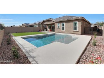 Beautiful backyard with a refreshing pool and well-manicured landscaping and artificial grass at 18509 W Galveston St, Goodyear, AZ 85338