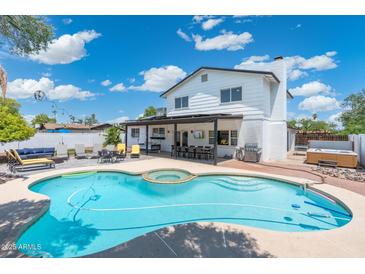 Gorgeous swimming pool and spa, with an outdoor kitchen, and multiple seating areas at 5101 E Winchcomb Dr, Scottsdale, AZ 85254