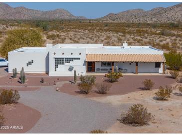 Charming single-story home with a covered front porch, desert landscaping, and mountain views at 10020 W Tortalita Way, Casa Grande, AZ 85194