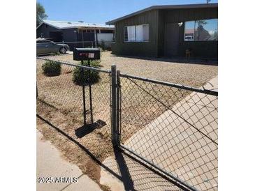 View of a well-kept yard with desert landscaping and a chain-link fence at 1113 E Bisnaga St, Casa Grande, AZ 85122