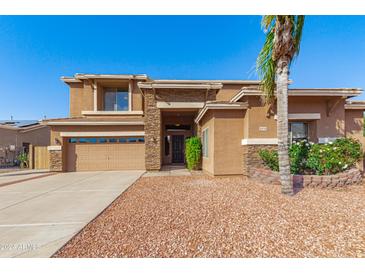 Charming two-story home featuring a stone facade, well-manicured landscaping, and a spacious driveway at 1870 E Indigo Dr, Chandler, AZ 85286